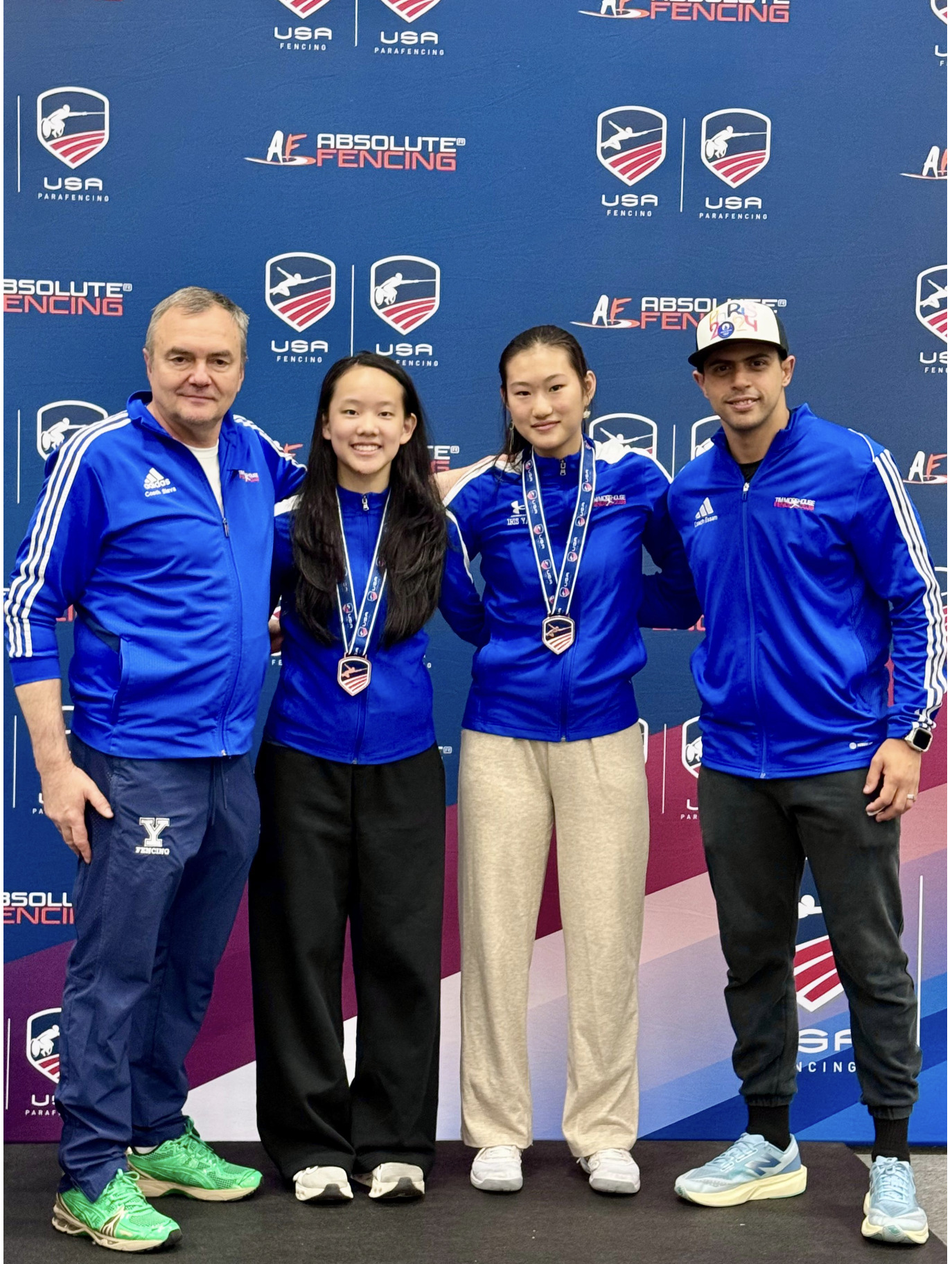 Iris Yang and Grace Feng of Tim Morehouse Fencing Club with their Division I Women's Foil medals and Coaches Slava Grigoriev and Mohamed Essam at the 2026 USA Fencing Summer National Championships in Portland