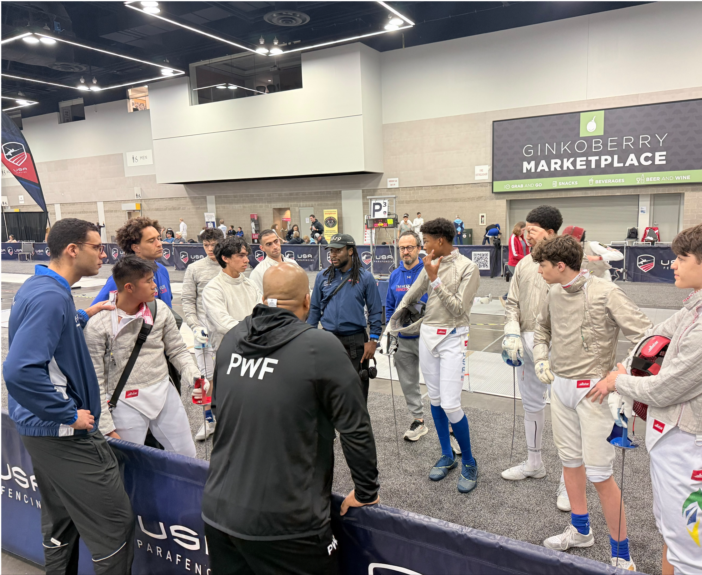 TMFC fencers huddle with their coaches at the 2026 USA Fencing Summer National Championships in Portland